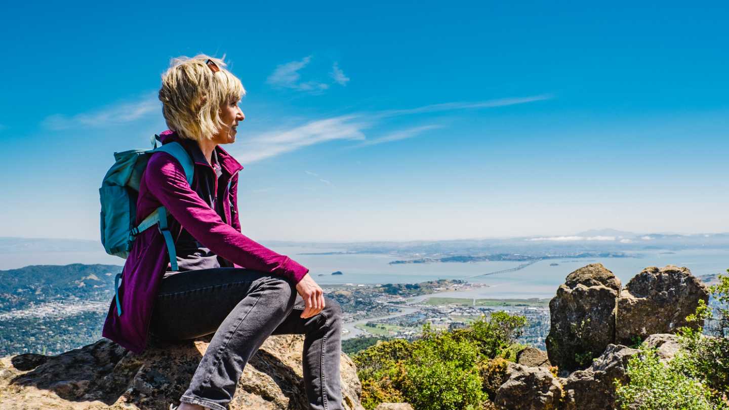 Hiker sitting on ledge overlooking Marin County