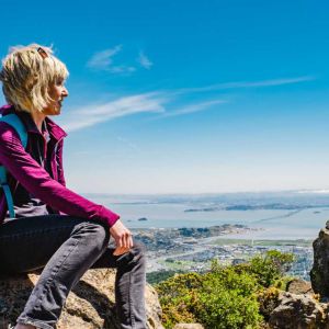 Hiker sitting on ledge overlooking Marin County