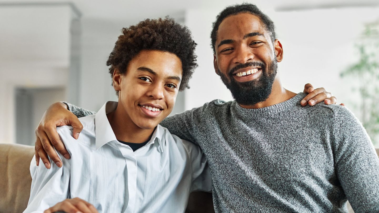 Father and son with arms across shoulders