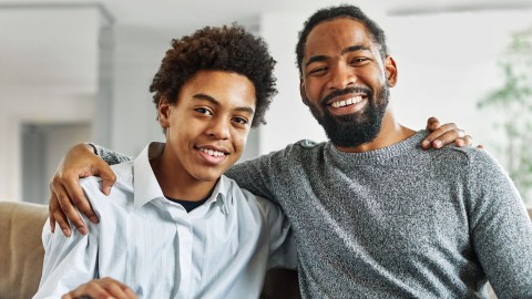 Father and son with arms across shoulders