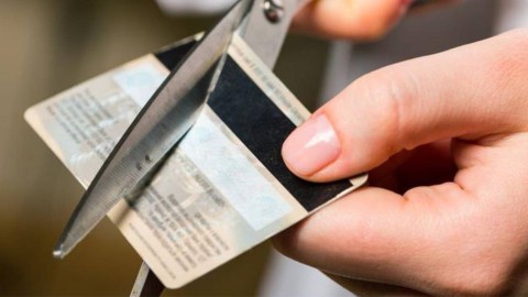 Person cutting a credit card with scissors