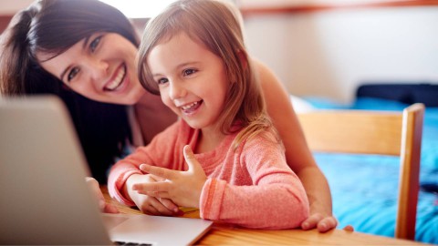 Mom and daughter using laptop in a room